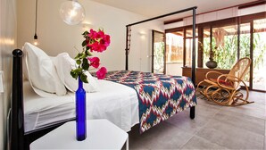 A modern bedroom with a bed, a blue vase, and a chair.