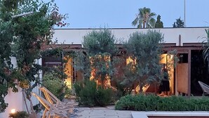 A modern outdoor patio with a pool, stone flooring, and lounge chairs.