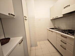 Een koelkast, kookgerei, borden en bestek