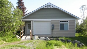 A single-story house with a garage, a small porch, and a stone pathway leading to the entrance.