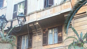 A two-story building with a central entrance, a small garden area with a tree, and a staircase leading to the entrance. - Rome-Trastevere. Ideally located. All within walking distance. Internet (Rome)