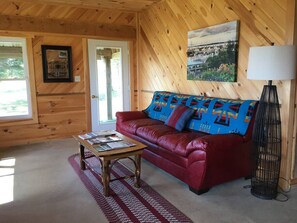 A cozy room with a red leather couch, a wooden coffee table, and a lamp.