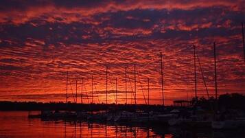 Atardecer sobre un puerto deportivo con barcos amarrados.