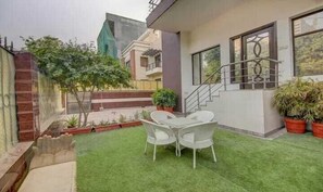 A modern house with a small patio, a staircase, and potted plants. - Hotel Vista (Noida)