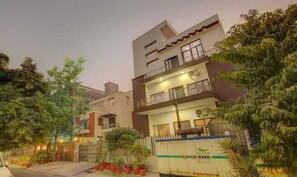 A multi-story residential building with balconies, a gated entrance, and potted plants. - Hotel Vista (Noida)