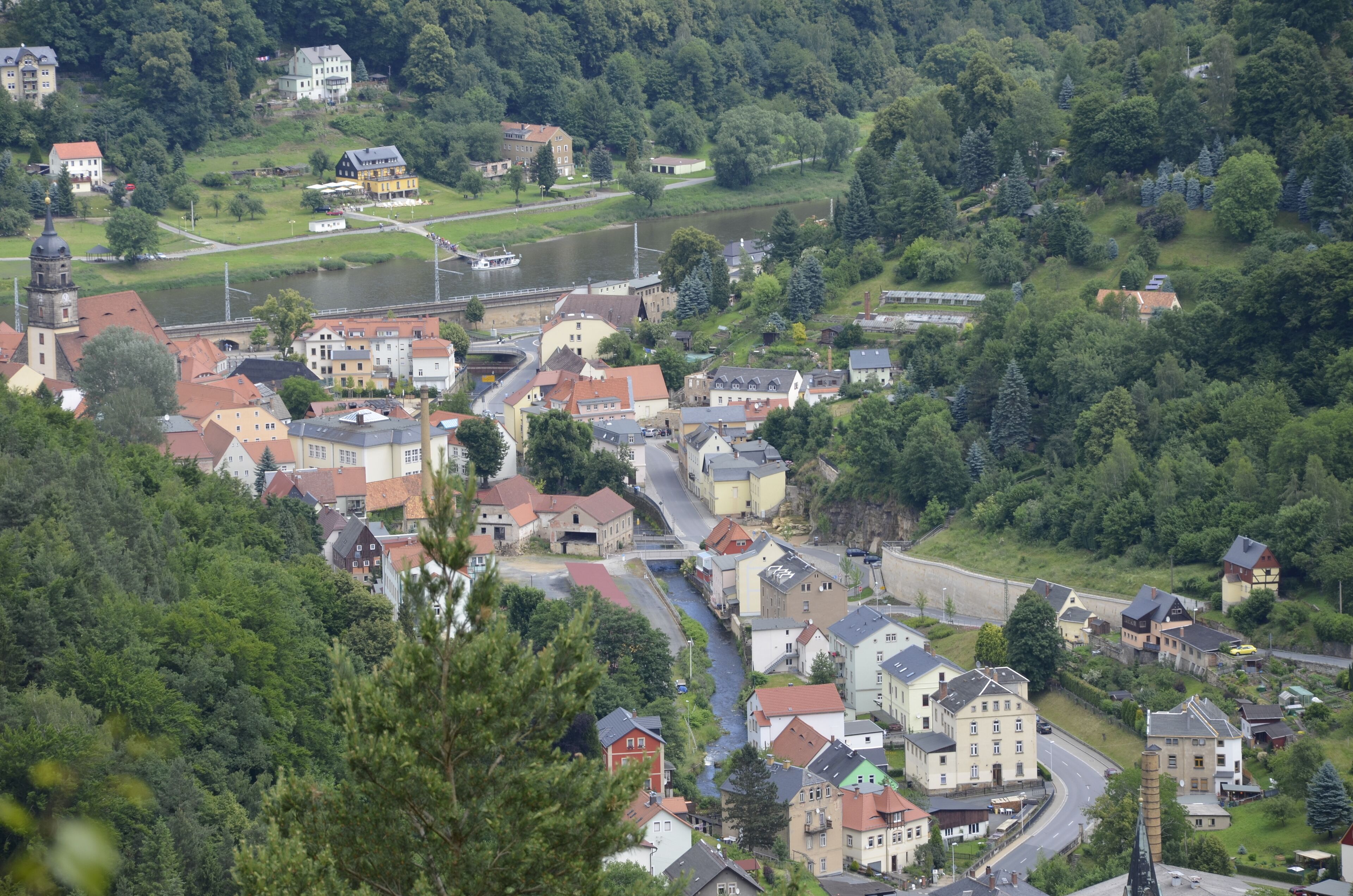 Eine Stadt mit einem Fluss, Häusern und einer Kirche.