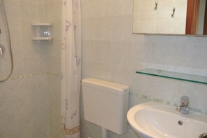 A bathroom with a toilet, sink, and shower.
