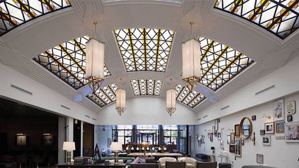 A spacious lobby with a high ceiling, large windows, and a central seating area.