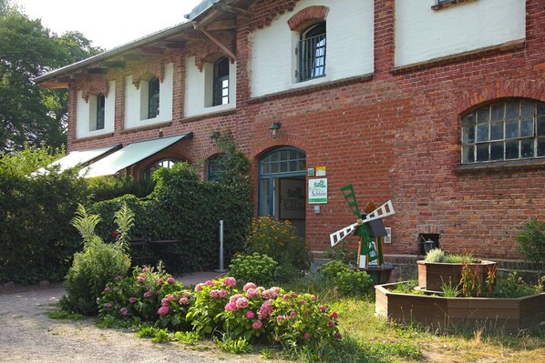 Ein Backsteinhaus mit einer grünen Markise und einem Schild, auf dem "Friedrich Schlosser" steht.