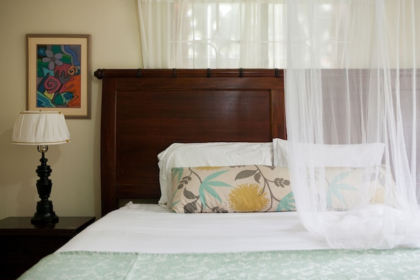 King size bed with night tables & lamps, mosquito net,  chest of drawers, mirror