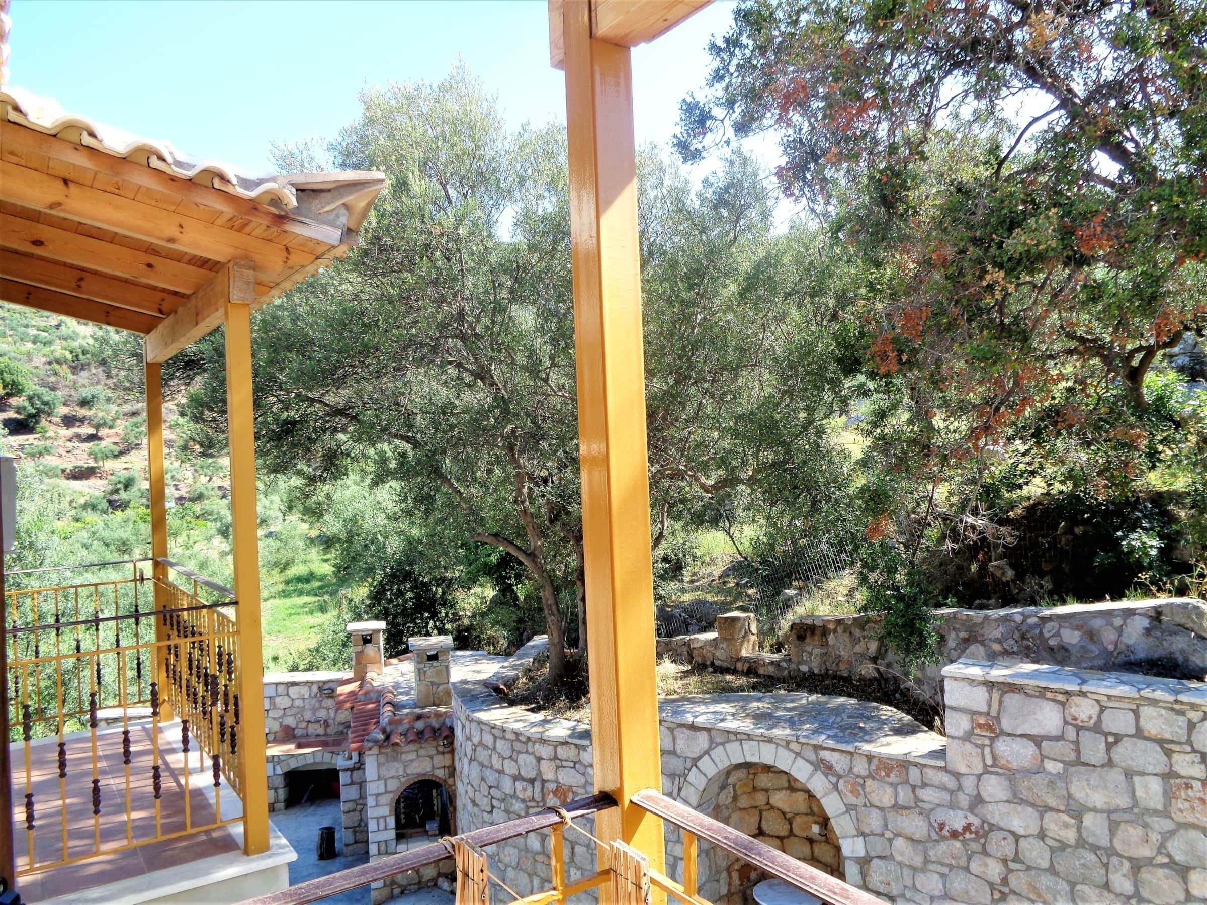A stone-built outdoor area with a pergola and a stone oven.