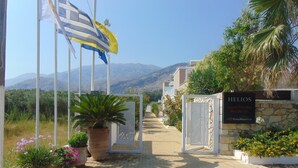 A gated entrance to Helios Luxury Holiday Residences with a clear view of mountains in the background.