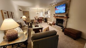 A cozy living room with a fireplace, comfortable seating, a television, and a dining area. - Main St/Town Lift/Hot Tub/Parking (Park City)