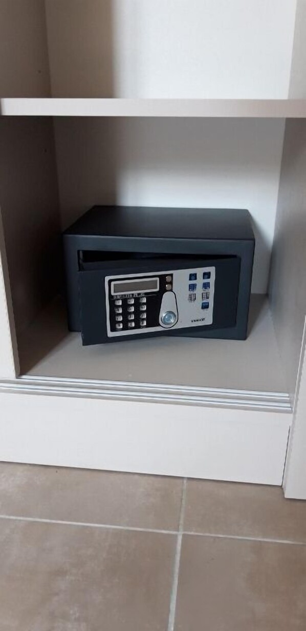A black electronic device on a white shelf in a room with tiled flooring. - A Storia (Bastia)