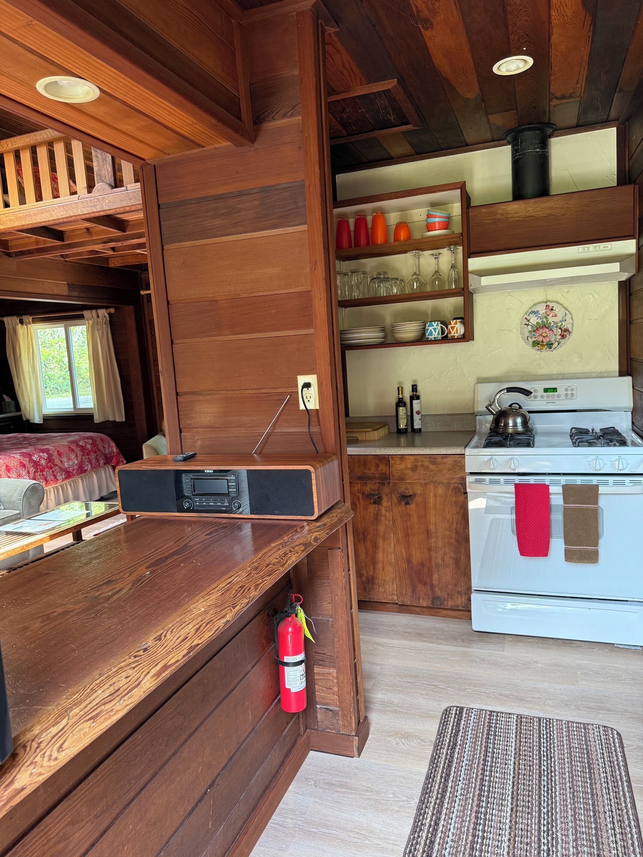 A compact kitchen with wooden cabinetry, a white stove, and a small countertop.
