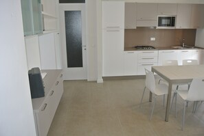 Een koelkast, een vaatwasser, kookgerei, borden en bestek