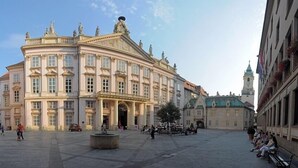 Un edificio histórico con arquitectura clásica, un patio central y una torre del reloj al fondo.