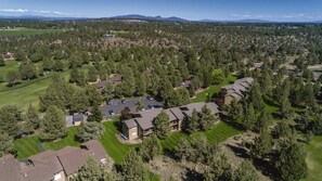 An aerial view of a residential area with multiple houses, green lawns, and a golf course. - Awesome summers and gorgeous winters! (Redmond)