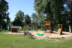 Leikkikentällä on keinut, liukumäki ja pieni varasto.