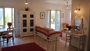 Un dormitorio con cama, escritorio, silla, armario y espejo.