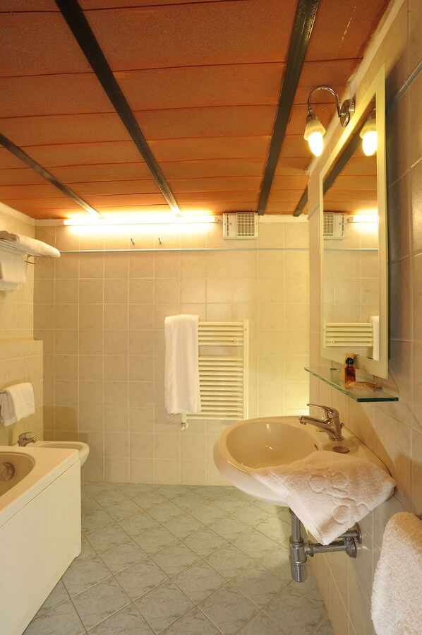 Een badkamer met een wastafel, spiegel en handdoekhouder.