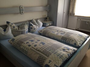 Relax in this serene bedroom with a single bed, adorned with pillows and a bedside table.