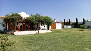 A house with a white exterior, a wooden porch, and a well-maintained lawn.