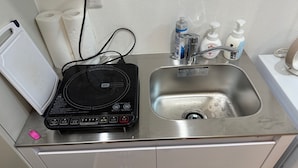 A bathroom with a sink, toilet paper, hand soap, and a portable induction heater. - Near Shibuya! Bright and Clean Olympic Park (Setagaya)