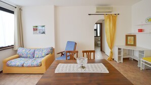 A living room with a sofa, a chair, a table with a glass vase, and a yellow curtain. - EUR Chianesi - IFO (50mt) strategico bilo, ben collegato A/C parcheggio (Rome)