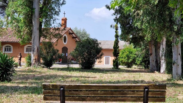A bench in a park with a building in the background. - EUR Chianesi - IFO (50mt) strategico bilo, ben collegato A/C parcheggio (Rome)