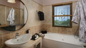 Une salle de bain avec un lavabo, un miroir, une baignoire et une fenêtre.