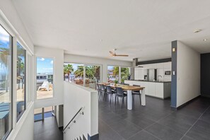 Uma cozinha moderna com área de jantar, janelas amplas e vista para o exterior.