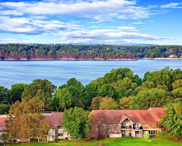 A coastal property with a stone house, a grassy lawn, and a view of the sea and forested hills. - All the comforts of home! (Afton)