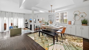 A spacious living area with a dining table, bench, and sofa.