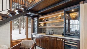 Une cuisine moderne avec des meubles en bois, un plan de travail en pierre et une cuisinière intégrée.