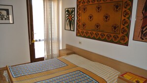 Une chambre à coucher avec un lit, une table de chevet, une tête de lit en bois et une fenêtre avec des rideaux.
