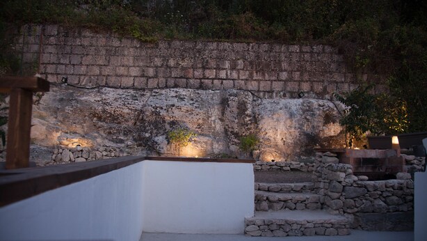 Un muro de piedra con escalones que conducen a una pared blanca.