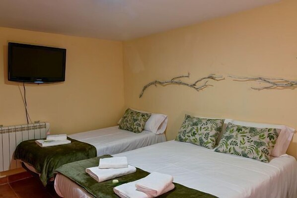 Een hotelkamer met twee bedden, een televisie en een decoratief wandobject.
