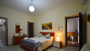 Un dormitorio con cama, mesitas de noche, espejo y un cuadro en la pared.