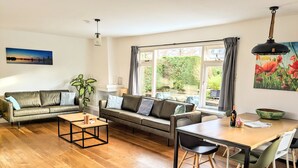 Una sala de estar moderna con sofá, mesa de centro y comedor.