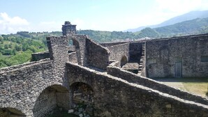 An ancient stone fortress with arched gateways and a watchtower. - An atmisfera suspended in time - Camera Brezza (Tresana)
