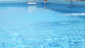A clear blue pool with a tiled edge and a ladder leading into it. - An atmisfera suspended in time - Camera Brezza (Tresana)