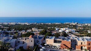 A coastal residential area with modern buildings, a clear view of the sea, and a distant cityscape. - Sandika apartment 8. The right place to be!!! (Koutouloufari)