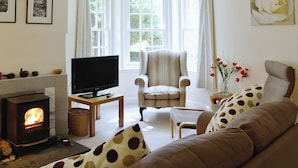 A cozy living room with a fireplace, a television, and comfortable seating.