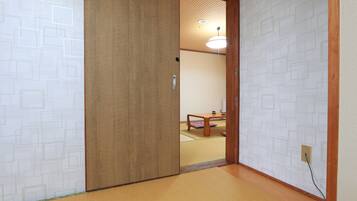 Um quarto japonês tradicional com tatames, uma porta deslizante e um lustre no teto.