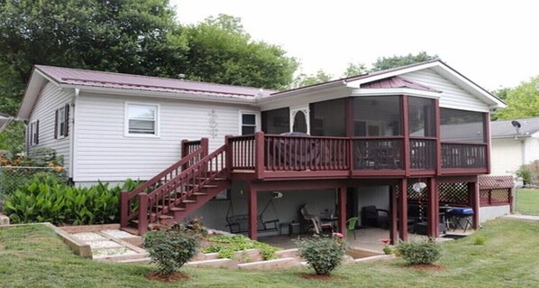 Ein zweistöckiges Haus mit einer Veranda und einer Treppe, die zum oberen Stock führt.