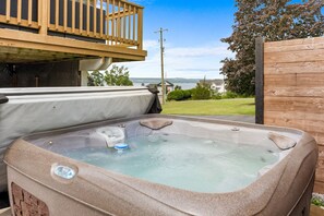 Un jacuzzi con vistas a un lago y casas al fondo.