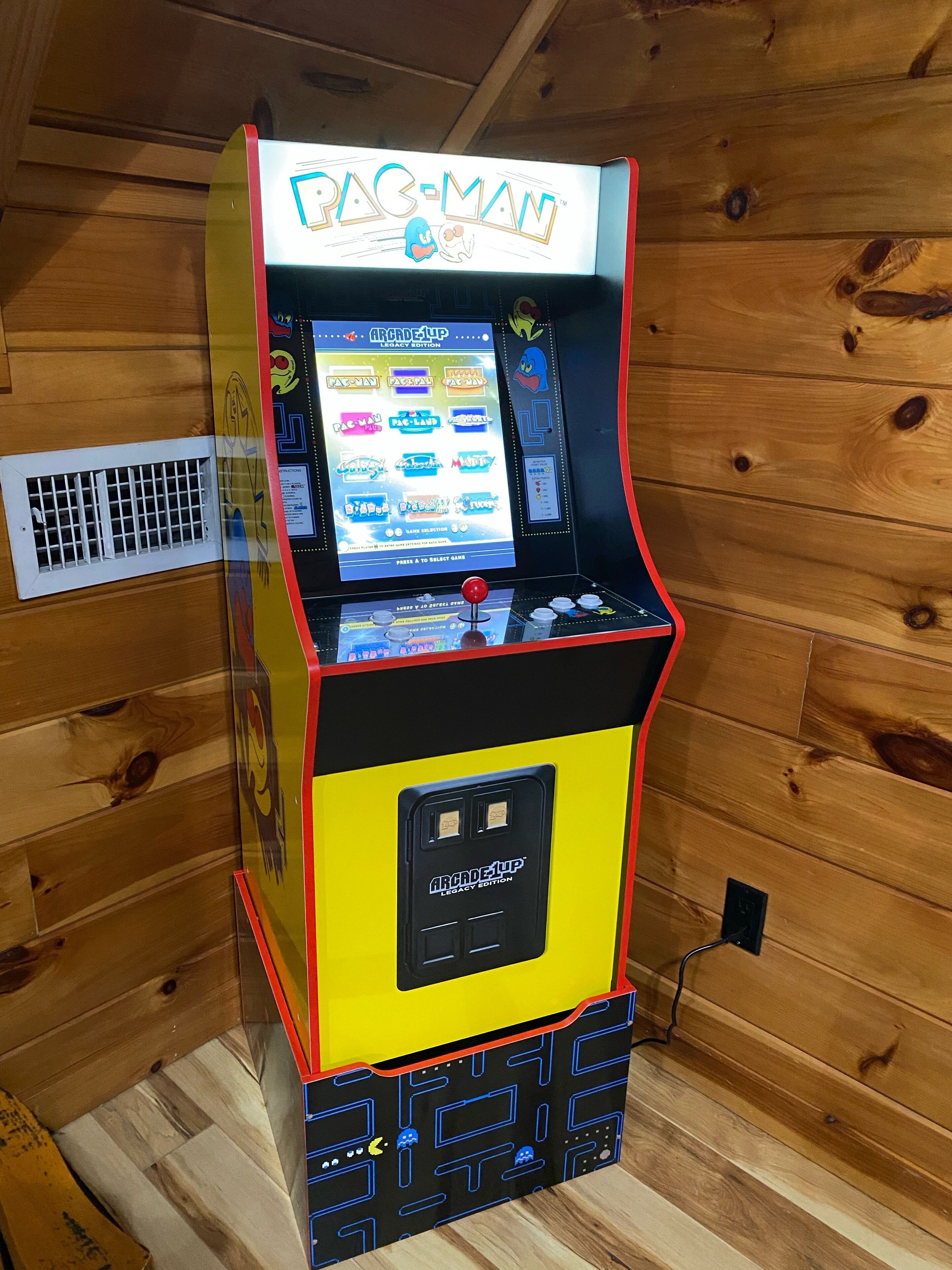 Une borne d’arcade Pac-Man dotée d’un écran de sélection et d’un joystick.