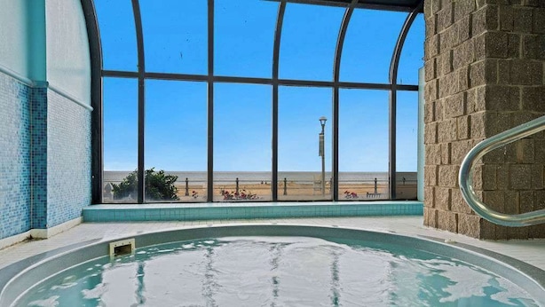 An indoor swimming pool with a clear view of the desert landscape through large windows. - Coastal 1BR Condo w/Indoor Pool & Ocean Access (Virginia Beach)
