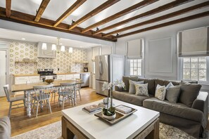 Amplia sala de estar con una mesa de comedor, un sofá y una cocina al fondo.